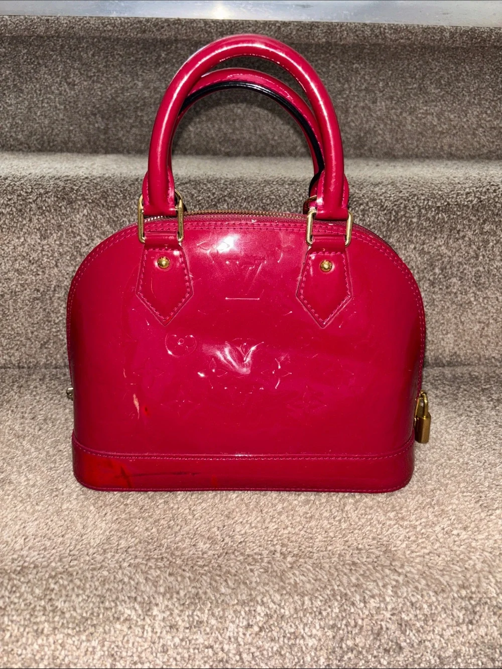 Red Louis Vuitton Alma BB crafted from glossy Monogram Vernis patent leather